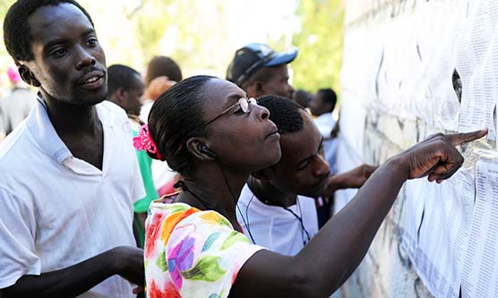 Kendra Helmer/USAID: Voters look for their names outside a polling station in Haiti in 2011, in the second round of the presidential elections.